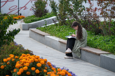 Rear view of woman standing by plants