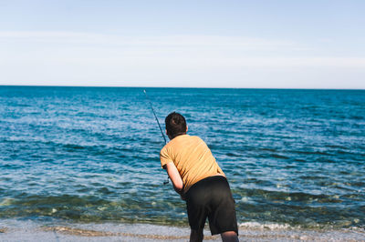 Rear view of man standing on beach