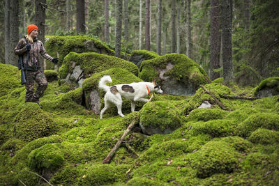 Woman with hunting dog in forest