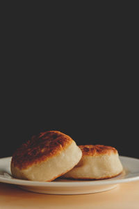 Close-up of bread on table against black background