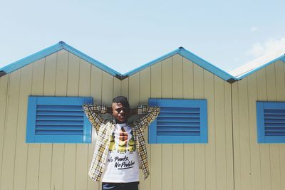 Portrait of man standing against blue sky