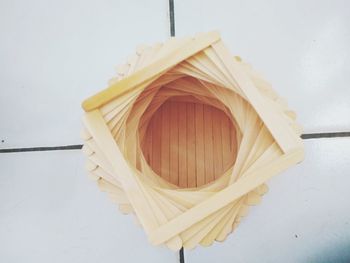 High angle view of paper hanging on table against white wall