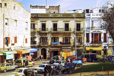 People on street against buildings in city