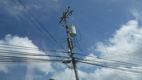 Low angle view of electricity pylon against sky