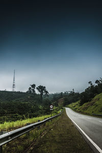 Empty road by mountain against sky