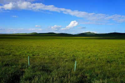 Scenic view of field against cloudy sky