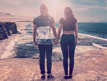 Rear view of couple standing at beach