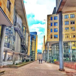 Buildings in city against cloudy sky