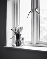 Flowers in vase on window sill at home