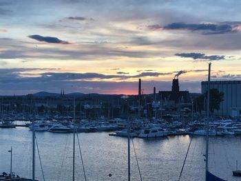 Boats moored at harbor during sunset