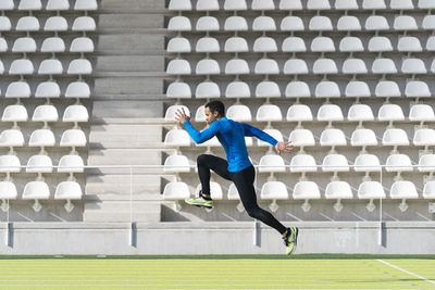 Full length of man jumping against wall