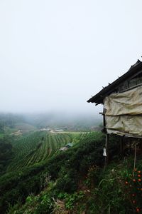 Countryside landscape against sky in foggy weather