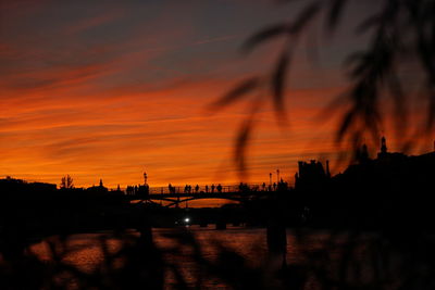 Scenic view of river against dramatic sky during sunset