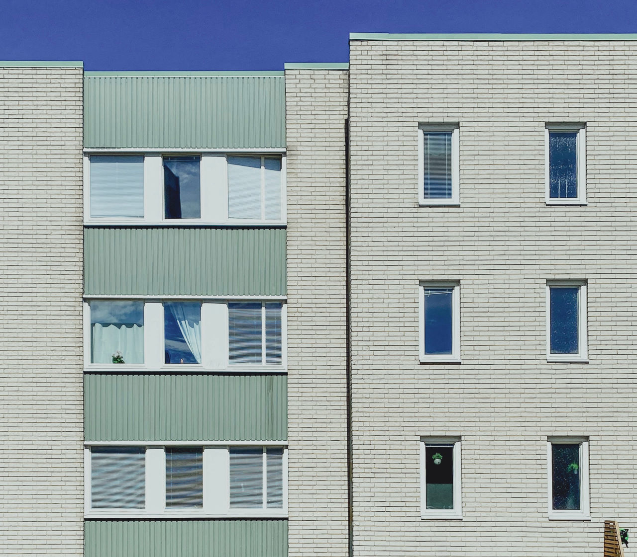 LOW ANGLE VIEW OF RESIDENTIAL BUILDING AGAINST BLUE SKY