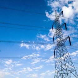 Low angle view of electricity pylon against cloudy sky