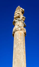 Low angle view of statue against blue sky