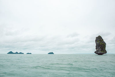 Scenic view of rocks in sea against sky