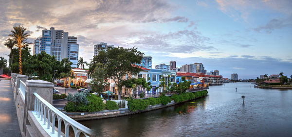 Christmas lights at sunset over the colorful shops of the village on venetian bay in naples, florida