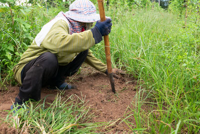 Side view of farmer with spade working field