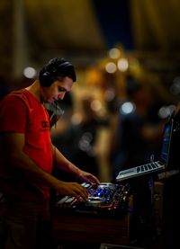 Side view of man using mobile phone at night