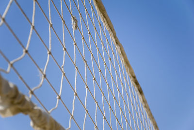 Low angle view of fence against clear blue sky