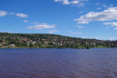 Scenic view of sea by buildings against sky