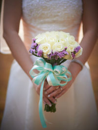 Midsection of woman holding flower bouquet