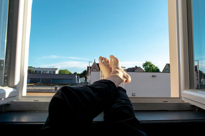 Low section of man relaxing on window