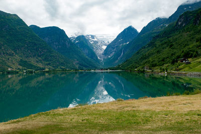 Scenic view of lake by mountains against sky