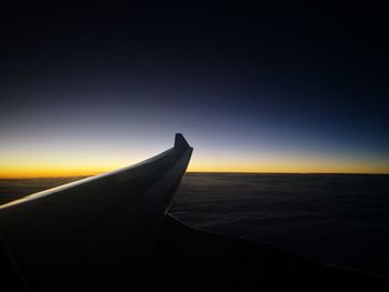 Close-up of airplane flying over sea against sky