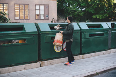 Full length of man throwing garbage in can