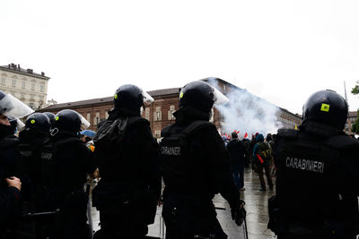 Rear view of people at town square against clear sky