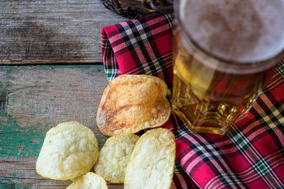 High angle view of potato chips by beer on table