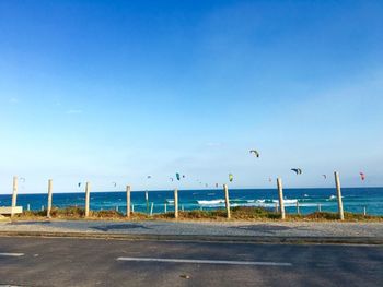 Road by sea against clear blue sky