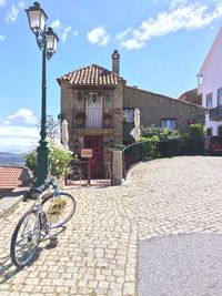 Bicycle by street against buildings in city