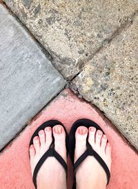 Low section of woman standing on footpath