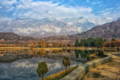 Scenic view of lake by mountains against sky