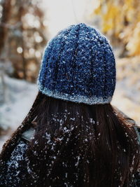 Rear view of woman wearing knit hat during snowfall