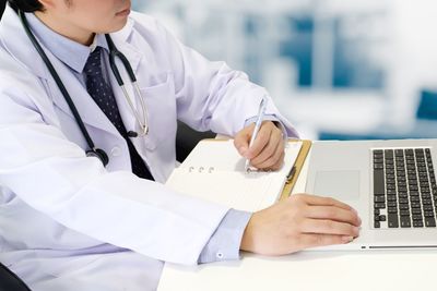 Midsection of man using laptop on table