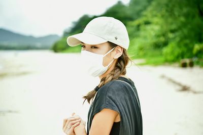 Portrait of young woman wearing cap standing outdoors