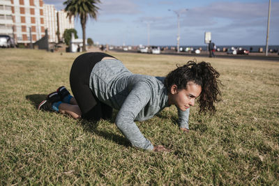 Woman doing push ups on the grass.