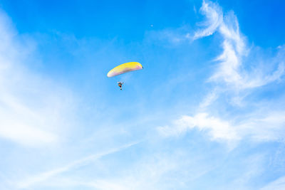 Low angle view of person paragliding against sky