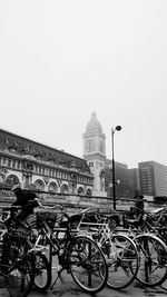 Bicycles on bridge against buildings in city