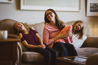 Smiling young woman sitting on sofa