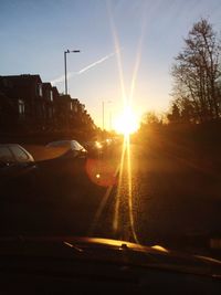 Cars on road against sky during sunset