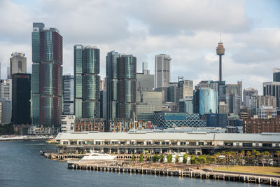 Modern buildings in city against cloudy sky