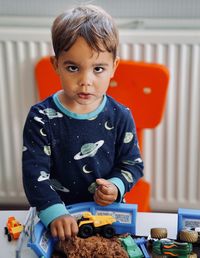 Portrait of cute boy with toy on table