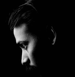 Close-up of young man against black background