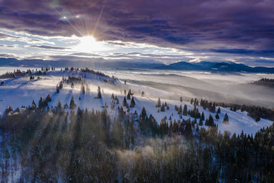 Scenic view of snow covered landscape against sky during sunset