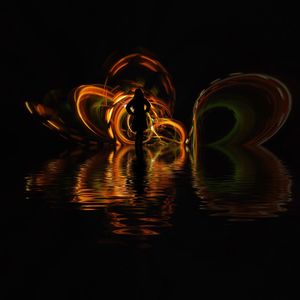Blurred motion of illuminated lighting equipment on water at night
